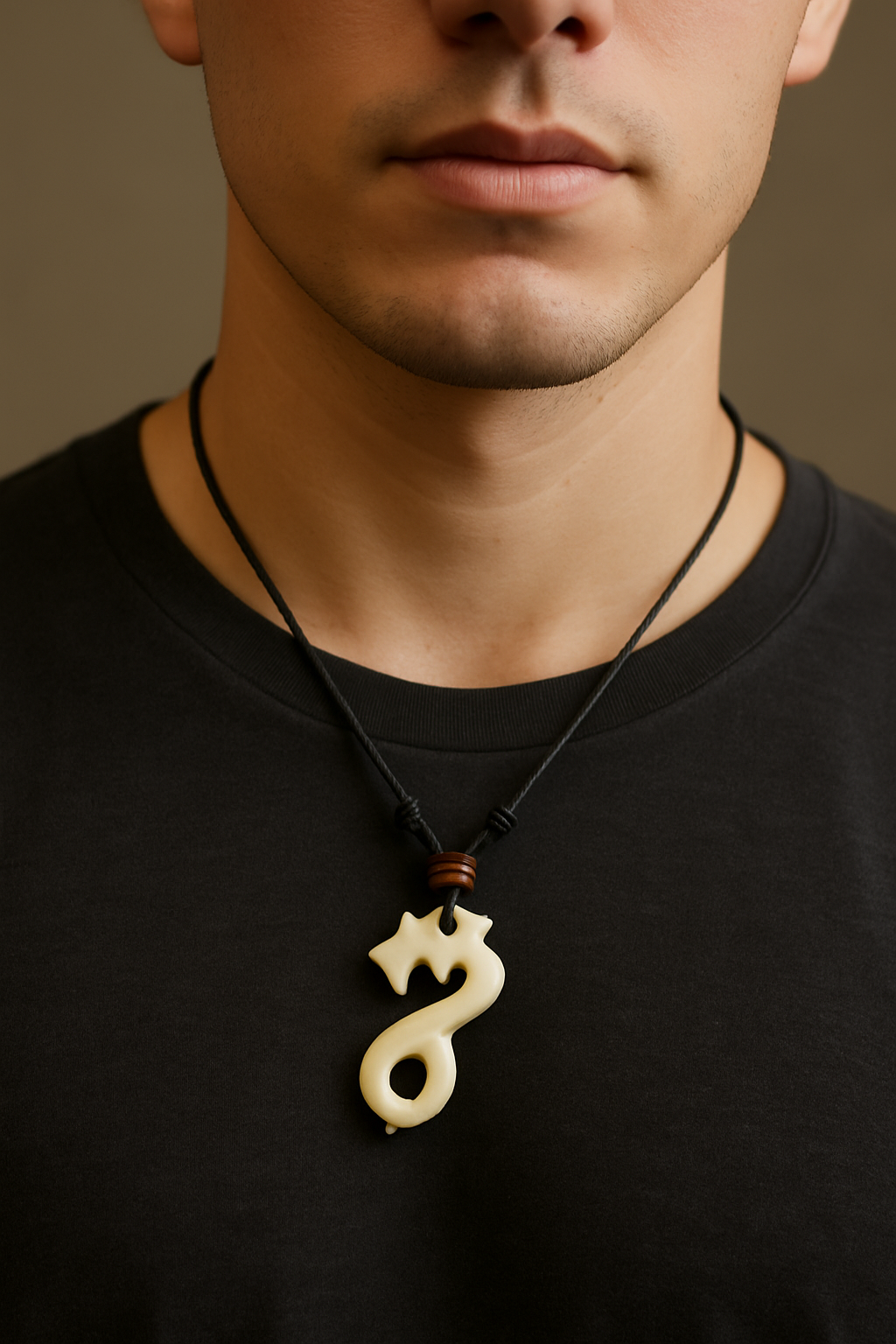 Man wearing a black shirt with a decorative necklace featuring a unique bone pendant.