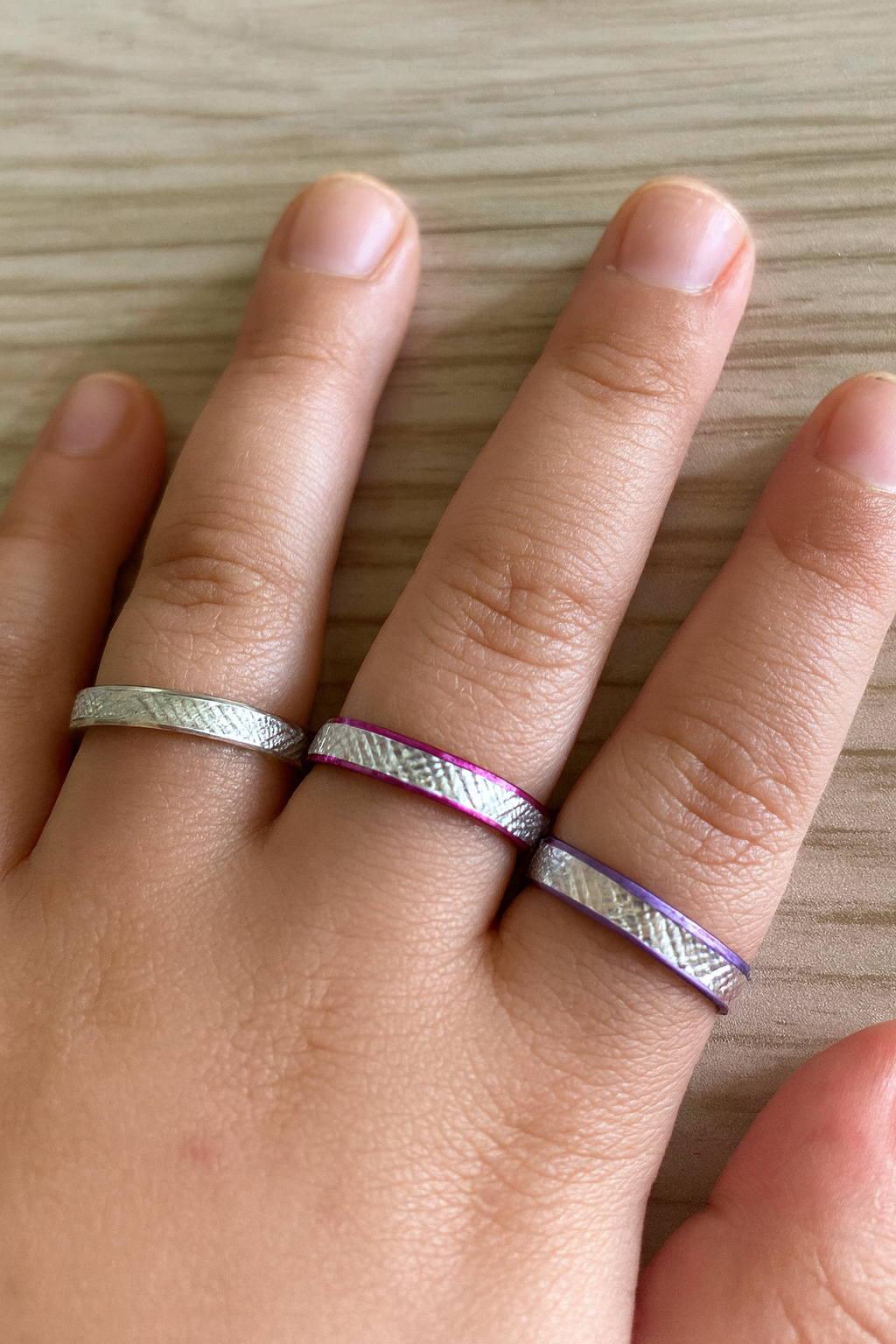 An image of a child’s hand with coloured aluminium rings on the fingers