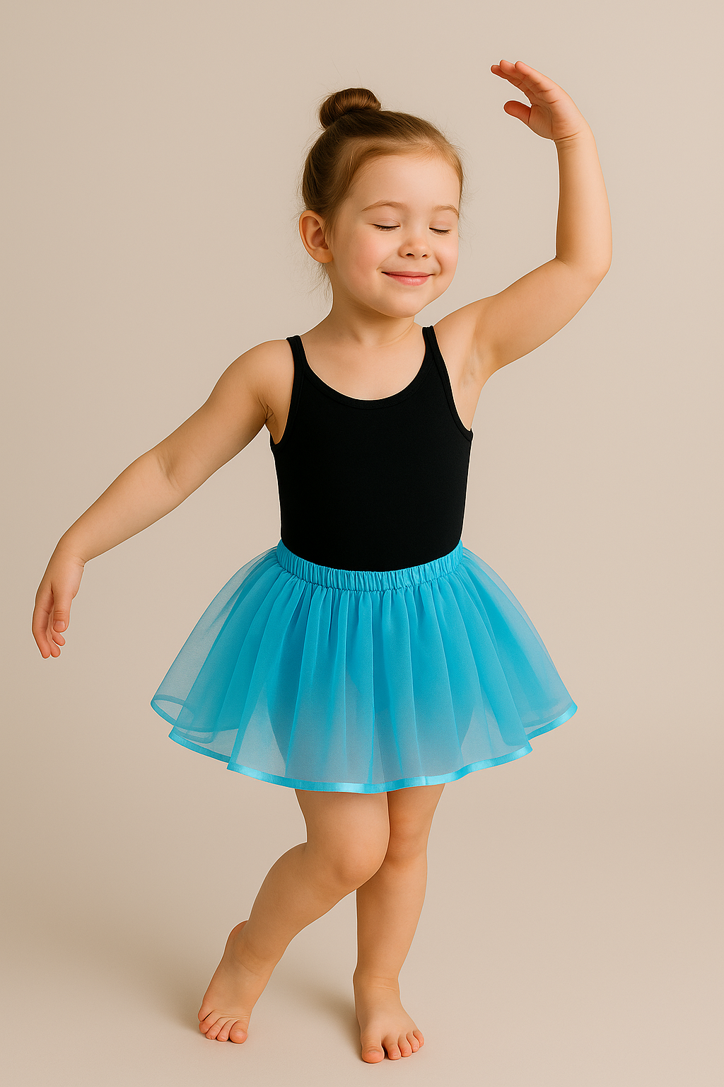 Young girl in a black leotard and blue tutu dancing on a beige background