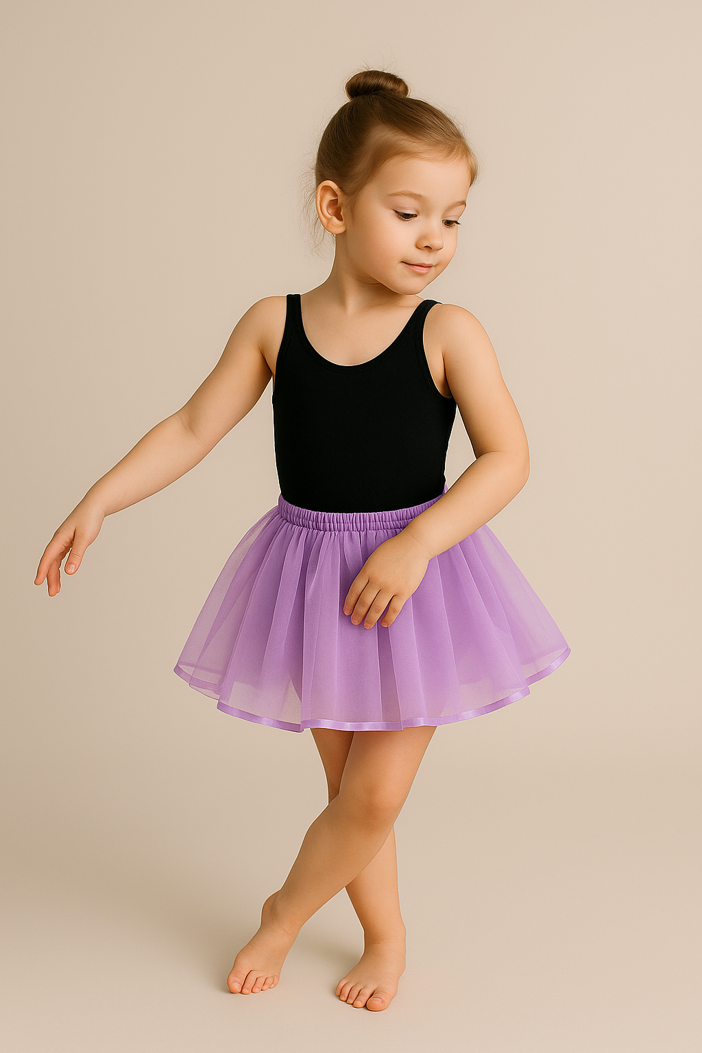 Young girl in a black leotard and flamigno tutu dancing on a beige background