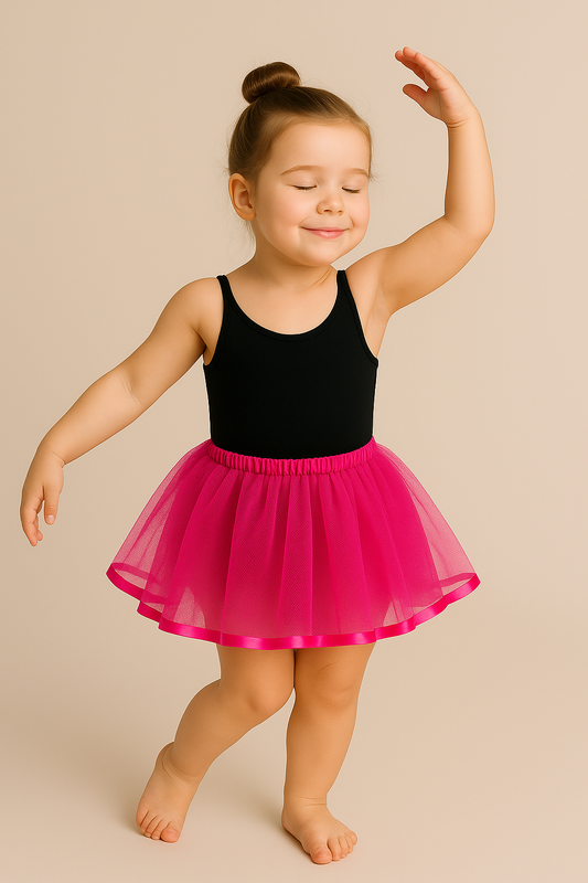 Young girl in a black leotard and lilac tutu dancing on a beige background