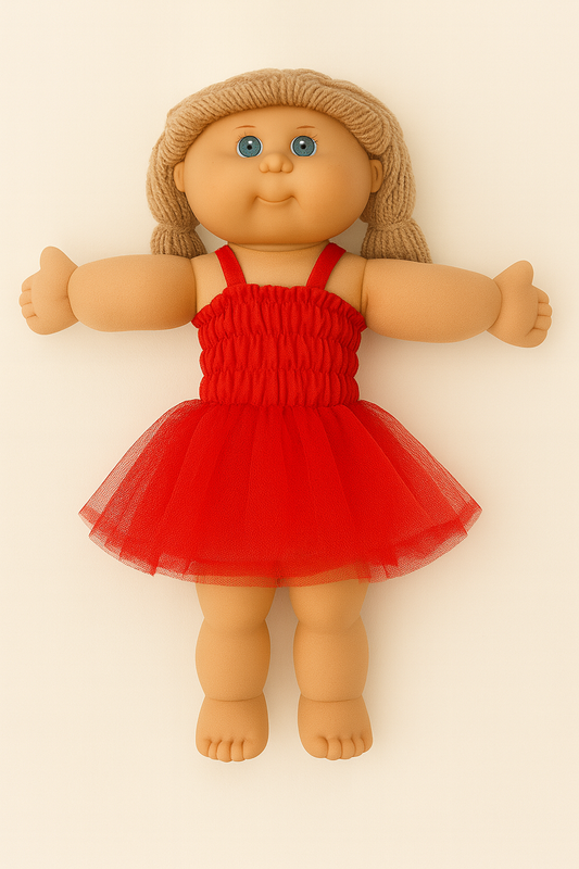 Cabbage Patch doll wearing a red dress with a plain background